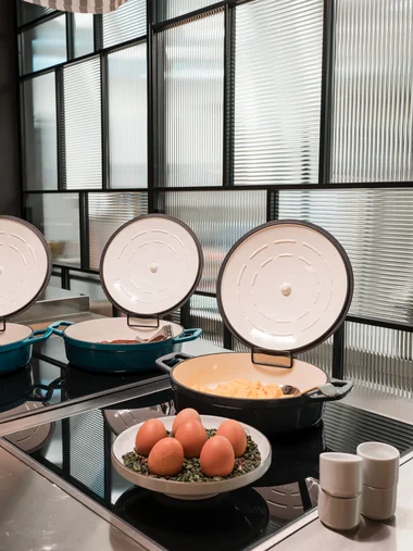 Ihr Start in den Tag: Frühstück in Königsbrunn Drei offene Töpfe mit Essen und eine Schale mit Eiern auf einer modernen Küchentheke