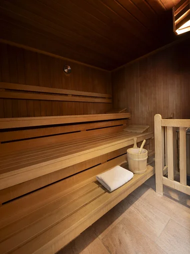 Hotel mit Sauna in Bayern: Zeller’s Quartier Leere Holzsauna mit Handtuch und Saunakübel mit Löffeln