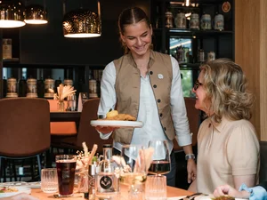 Cervus: das Restaurant in Königsbrunn mit dem gewissen Extra Kellnerin serviert einem Gast in einem Restaurant ein Gericht