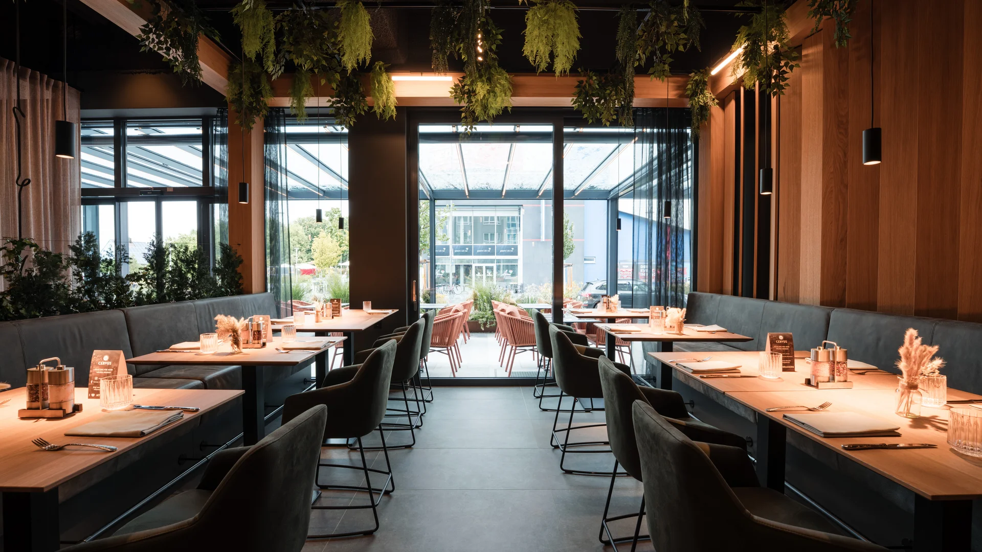 Cervus: das Restaurant in Königsbrunn mit dem gewissen Extra Modernes Restaurant mit Holztischen, grünen Pflanzen und großer Fensterfront
