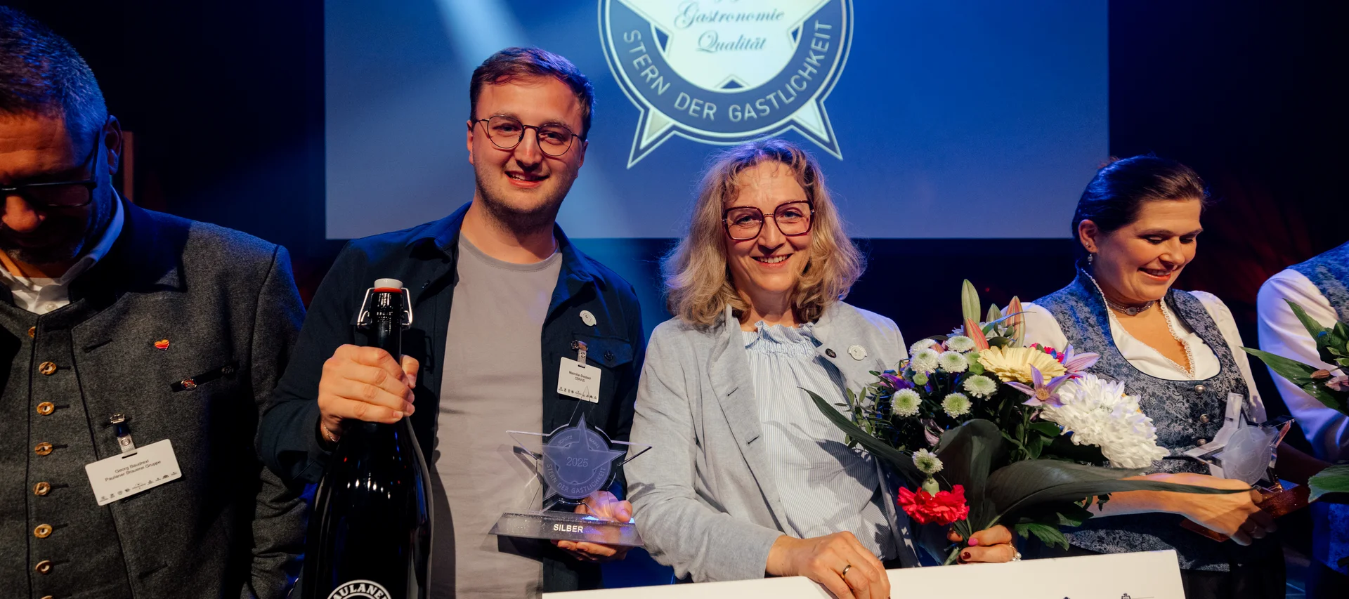 Goldener Stern für unser Cervus – wenn Leidenschaft ausgezeichnet wird Personen erhalten Silber-Auszeichnung Stern der Gastlichkeit bei Preisverleihung mit Blumen und Urkunde