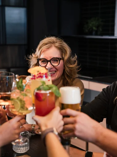 Ihr besonderes Hotel in Königsbrunn: Zeller’s Quartier Freundinnen stoßen mit bunten Cocktails und Bier in einer Bar an