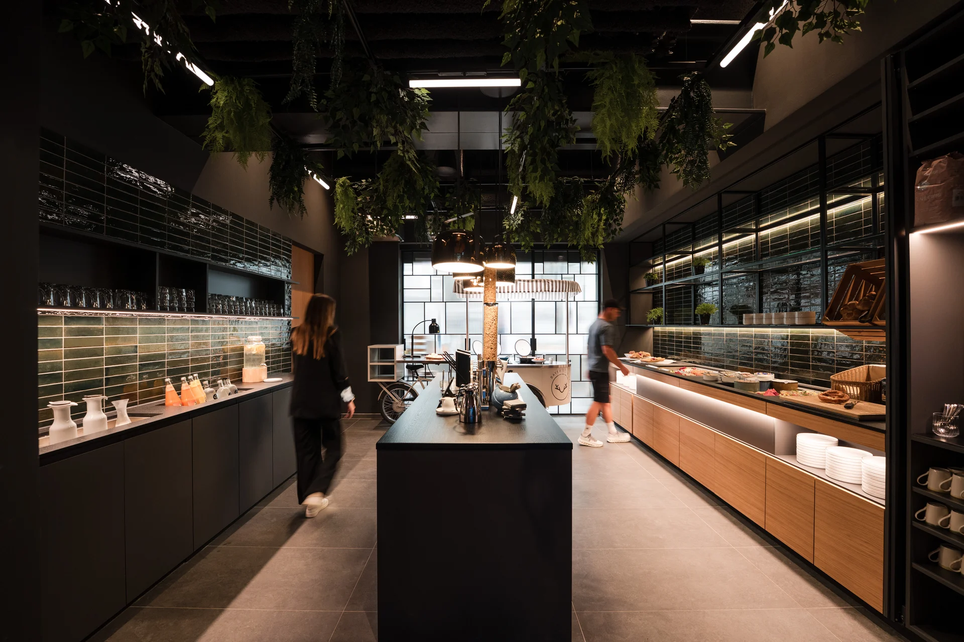 Ihr Start in den Tag: Frühstück in Königsbrunn Moderner Buffetbereich mit grünen Pflanzen und zwei Personen im Restaurant