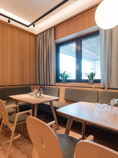 Cervus: Ihre Eventlocation in Augsburg und Umgebung Gemütlicher Essbereich mit Holzmöbeln und großer Fensterfront