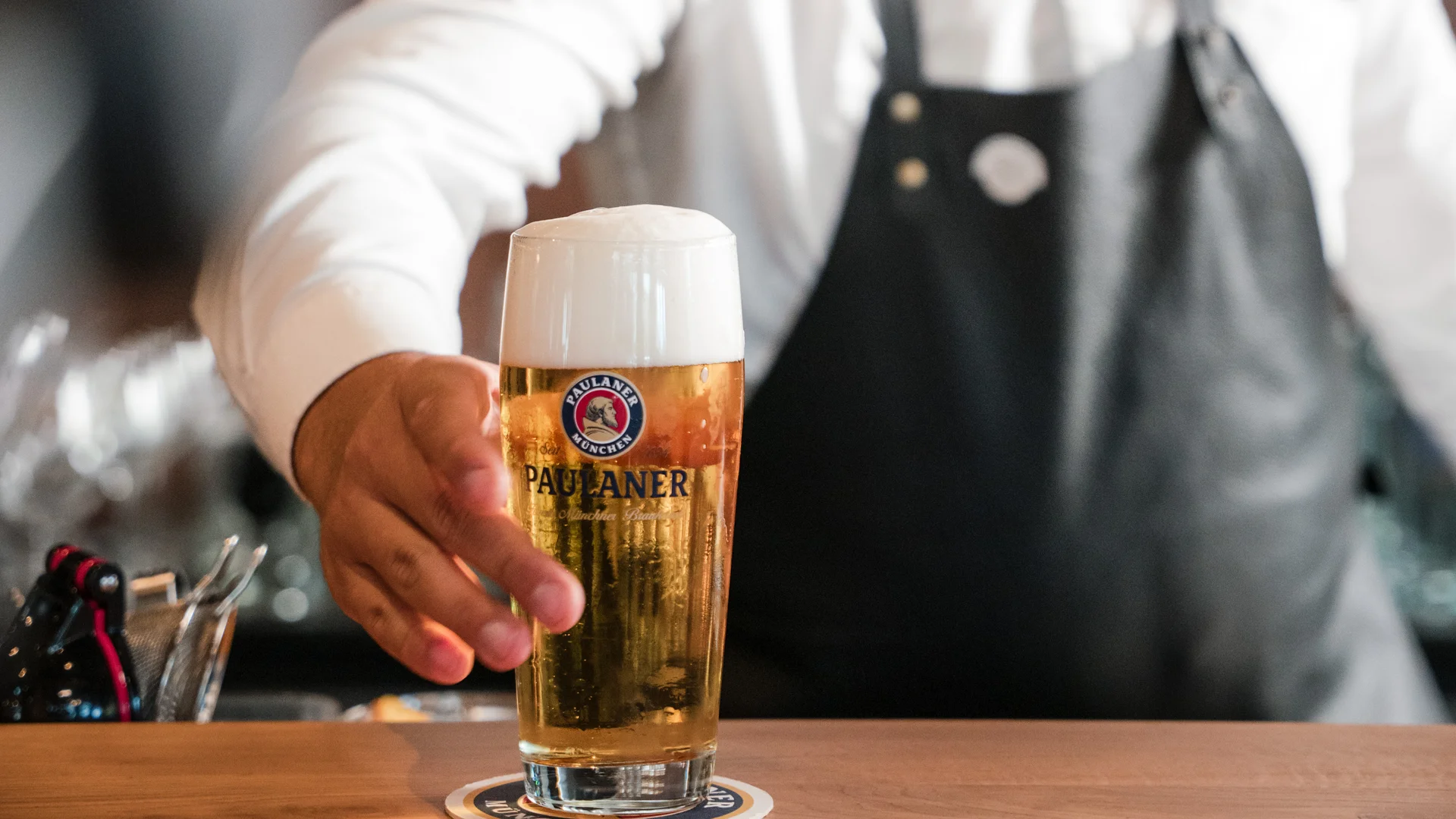 Biergarten rund um Königsbrunn gesucht? Barkeeper serviert frisches Paulaner Bier im Glas am Tresen