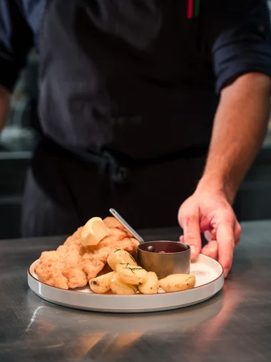 Cervus: das Restaurant in Königsbrunn mit dem gewissen Extra Koch serviert Wiener Schnitzel mit Kartoffeln und Sauce auf Teller