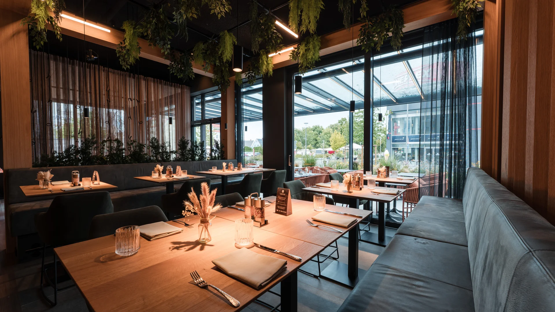 Ihr besonderes Hotel in Königsbrunn: Zeller’s Quartier Modernes Restaurant mit Holztischen, gemütlicher Bestuhlung und grünen Hängepflanzen